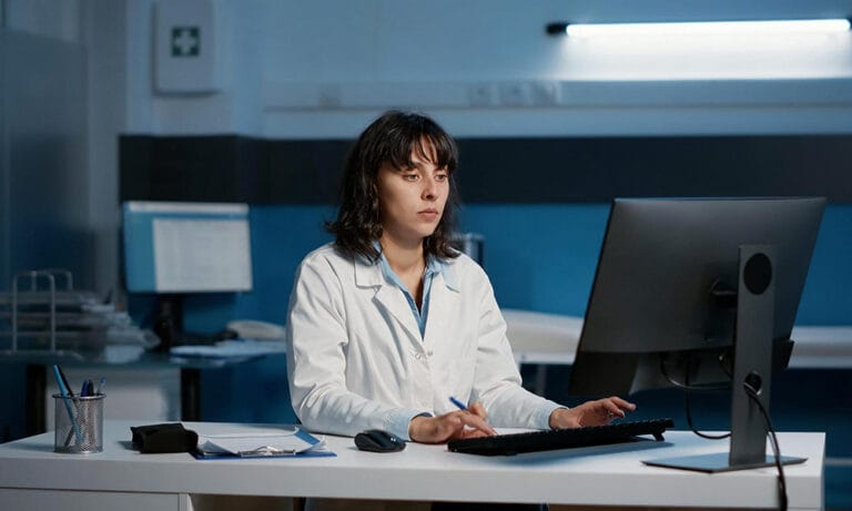 Clinical data professional reviewing study data on a computer during EDC system migration and clinical trial data management.